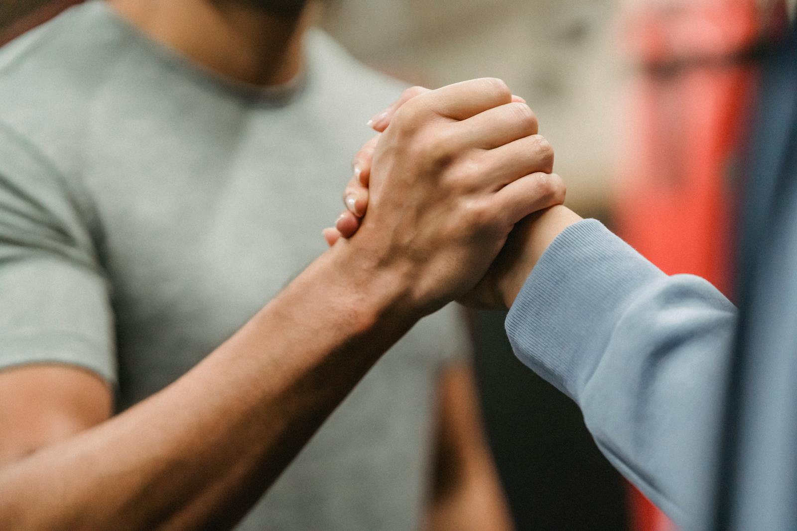 Photo by Julia Larson Crop sportive couple clasping hands in gym